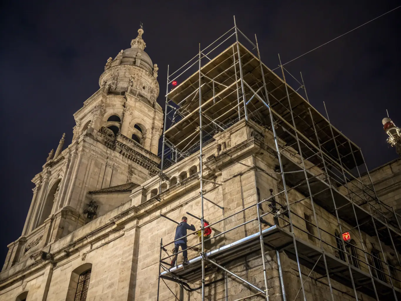 A photo of a restored chapel with scaffolding and conservation workers at work, highlighting the restoration process.